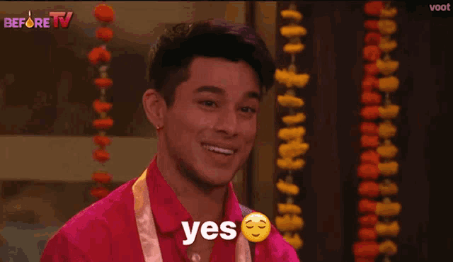 a man in a red shirt is smiling and the word yes is on his face