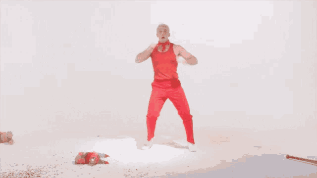 a man in a red shirt and red pants is dancing