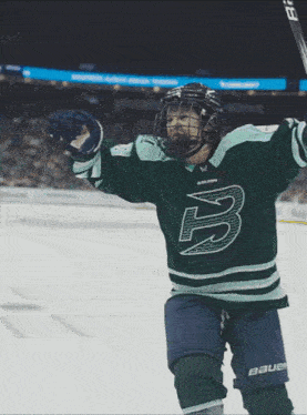 a hockey player wearing a green jersey with the letter b on the front