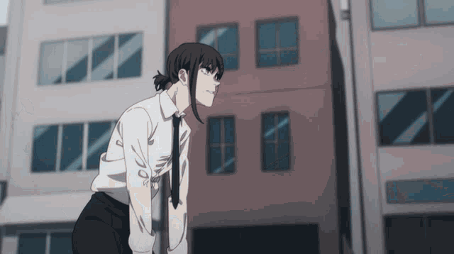 a woman in a white shirt and black tie is standing in front of a building