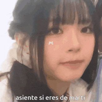 a close up of a girl 's face with the words asiente si eres de marti written below her .