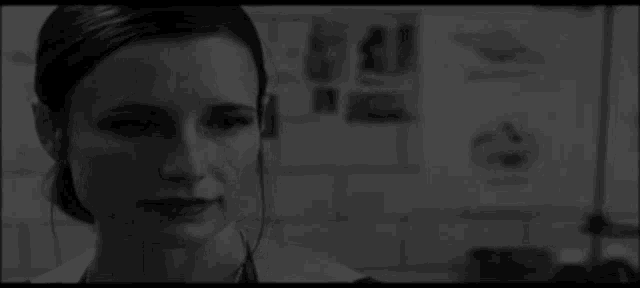 a black and white photo of a woman in a hospital room .