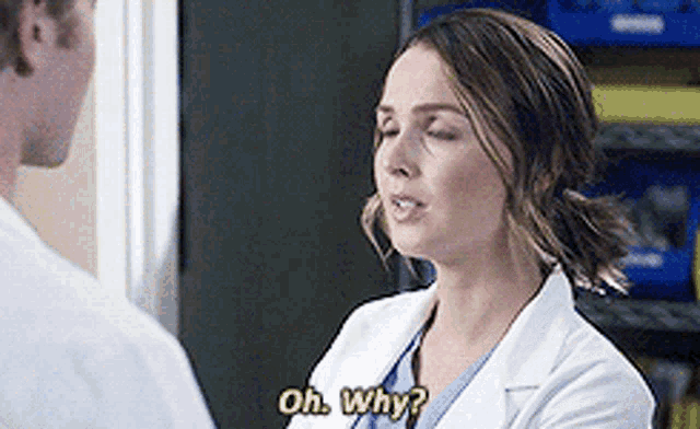a woman in a lab coat is talking to a man and asking him why