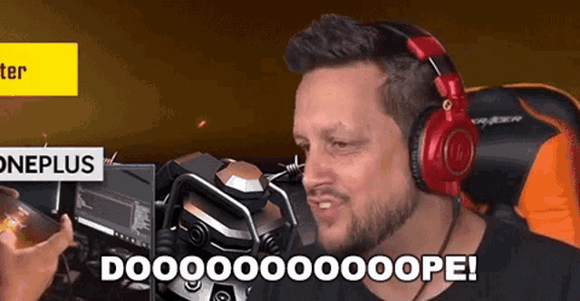 a man wearing headphones is sitting in front of a microphone and saying doo .