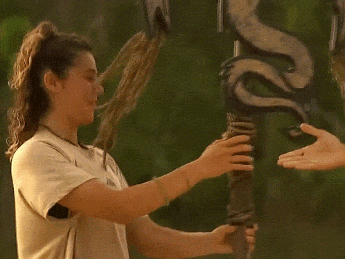 a woman holds a pole with a snake on it