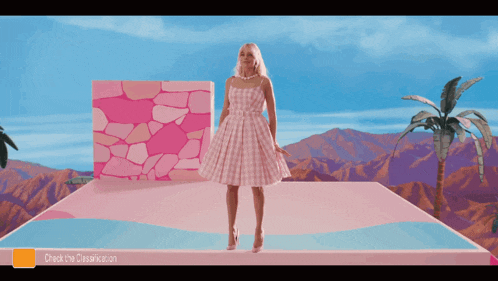 a woman in a pink dress is standing on a pink platform with mountains in the background