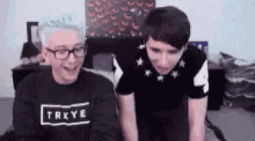 two men are sitting next to each other on a bed .