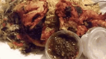a close up of a plate of food with two plastic cups of sauce .