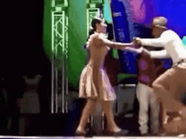 a man is dancing with a woman on a stage .