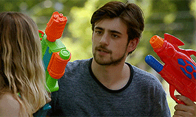 a man and a woman are holding water guns