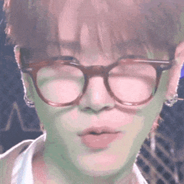 a close up of a person 's face with glasses and earrings