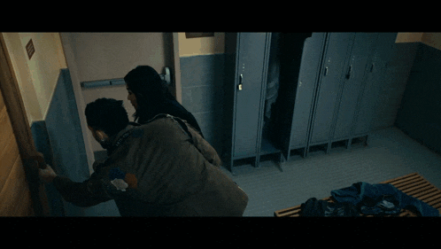 a man and a woman are looking out a door