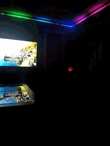 a dark room with a tv and a rainbow light