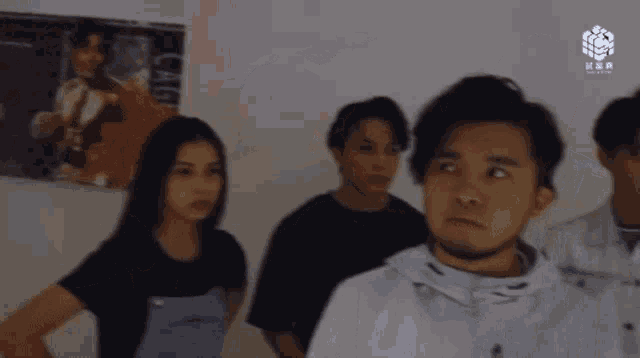 a group of young people are standing in front of a wall with a sign that says ' cube ' on it