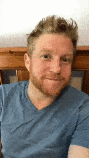 a man with a beard wearing a blue shirt