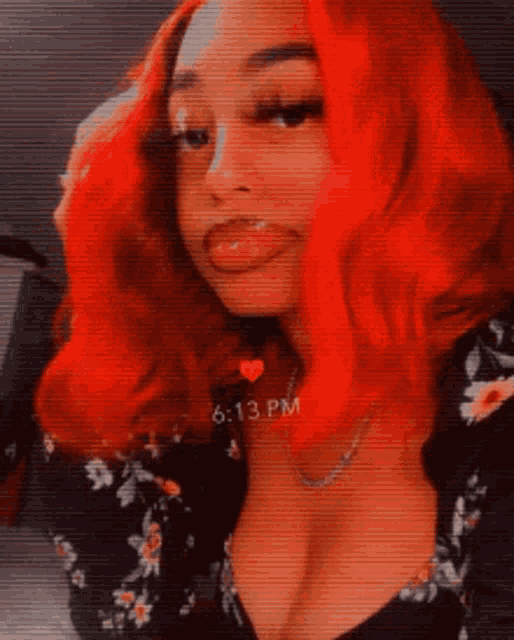 a woman with red hair is sticking her tongue out and wearing a necklace .