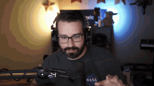 a man wearing glasses and a nasa shirt