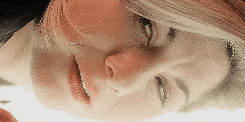 a close up of a woman 's face with a reflection in the mirror .