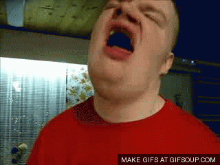 a man in a red shirt is yawning with his mouth wide open