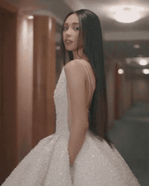 a woman is wearing a white dress with pearls on it