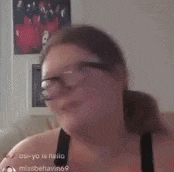 a woman wearing glasses is sitting on a couch in a living room .