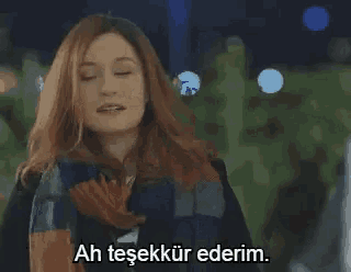 a woman wearing a scarf and a jacket is standing with her eyes closed and says ah tesekkür ederim .