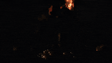 a group of soldiers are standing in front of a burning church with fireworks in the background