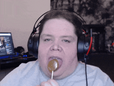 a man wearing headphones licking a lollipop in his mouth