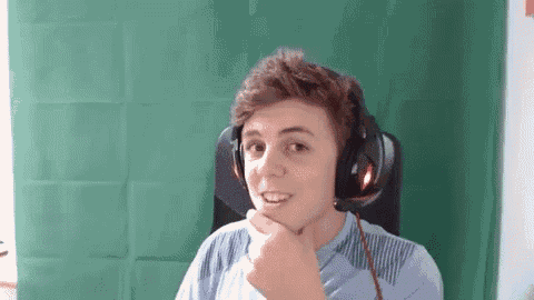 a young man wearing headphones is sitting in front of a green background .