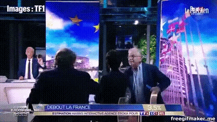 a man in a suit and tie talks to a woman in front of a sign that says debout la france