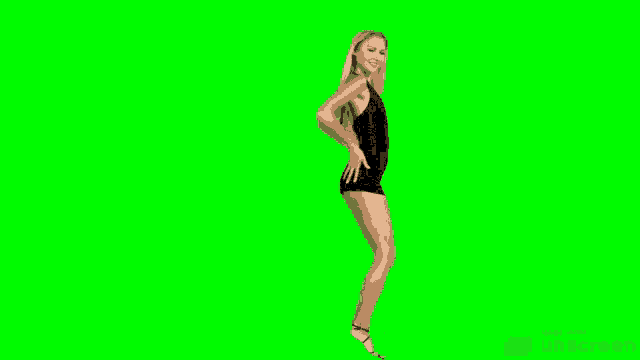a woman in a black dress and heels is dancing on a green screen