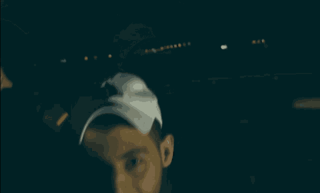 a man wearing a white hat with the letter a on it smiles