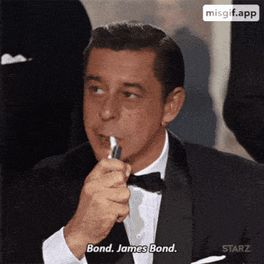 a man in a tuxedo lighting a cigarette and saying " bond james bond "