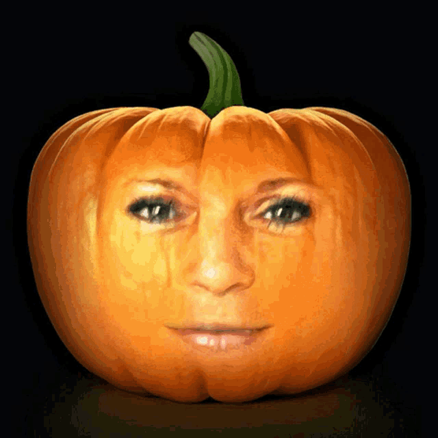 a pumpkin with a woman 's face carved into it on a black background