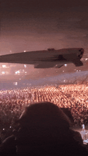 a plane is flying over a crowd of people at a concert and the plane says nasa on the side