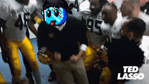 a group of football players are gathered in a locker room with ted lasso in the corner