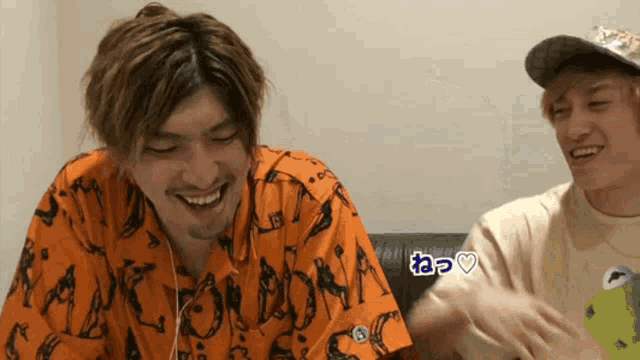 a man wearing an orange shirt that says tokyo on it is smiling