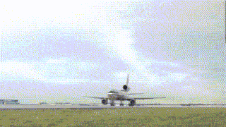 an airplane is taking off from a runway with a cloudy sky behind it