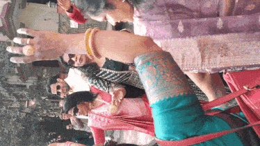 a woman wearing a ring on her finger is standing in a crowd