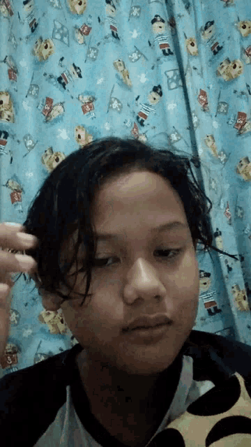 a young girl looks at the camera while holding her hair