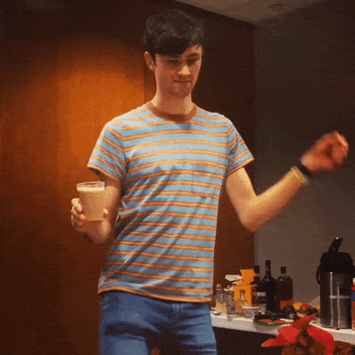 a man in a striped shirt is holding a cone