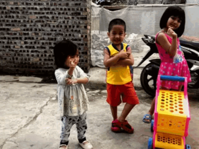 a boy in a yellow shirt is standing next to two girls