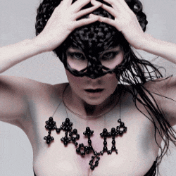 a woman wearing a black mask and a necklace with the word matt on her chest