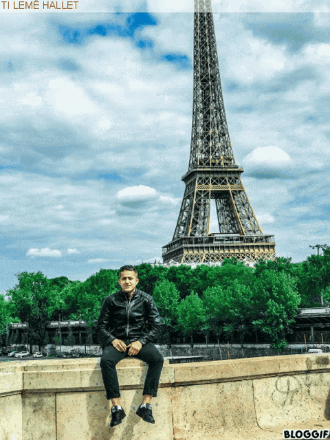 a man sits on a wall in front of the eiffel tower with the caption ti leme hallet