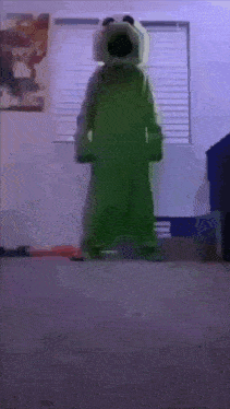 a person in a green costume is standing in a room