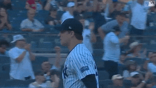 two baseball players are talking to each other in a stadium . one of the players is wearing a helmet .