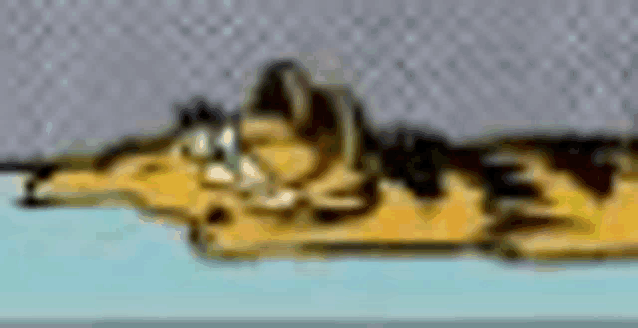 garfield the cat is laying on a table with a gray background .