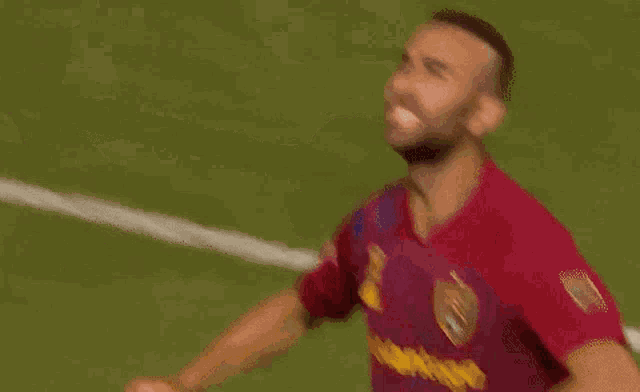 a soccer player in a red shirt is celebrating a goal on the field