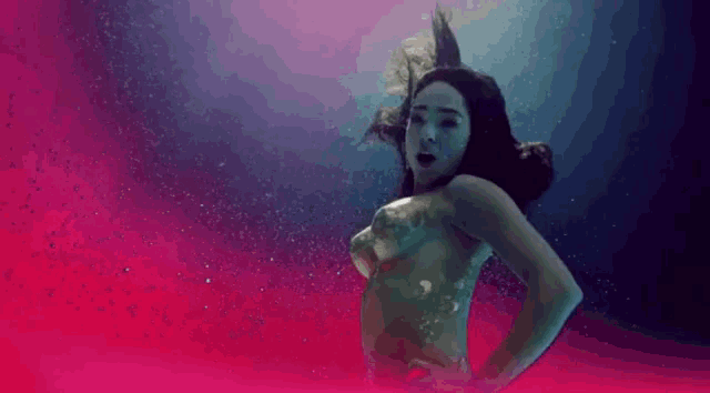 a naked woman is giving the middle finger while underwater