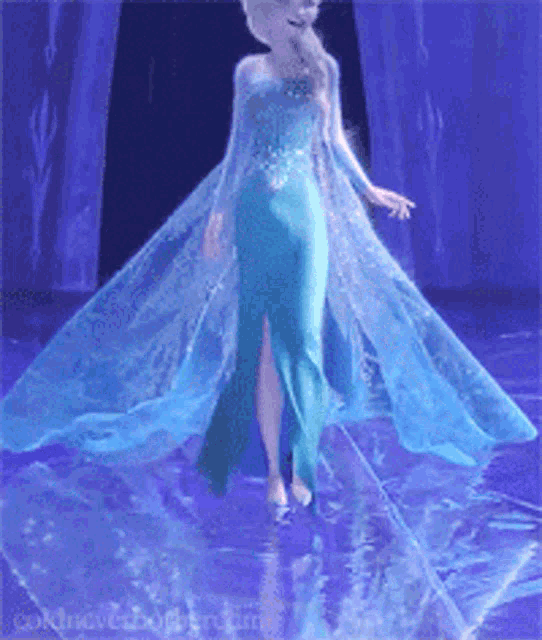 a woman in a blue dress is standing on a stage in front of a blue curtain